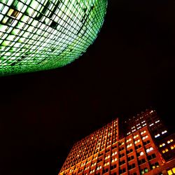 Low angle view of illuminated building against sky at night