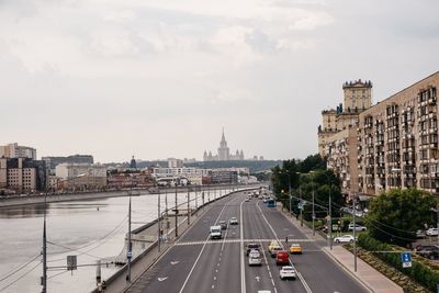 Vehicles on road in moscow city against sky