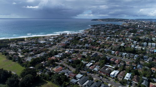 High angle view of townscape by sea against sky