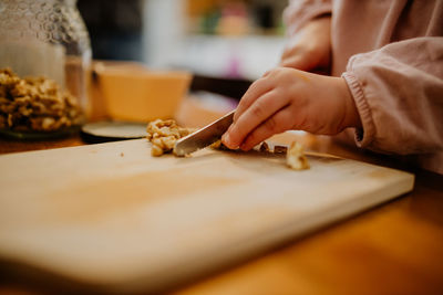 Child cutting walnuts for baking