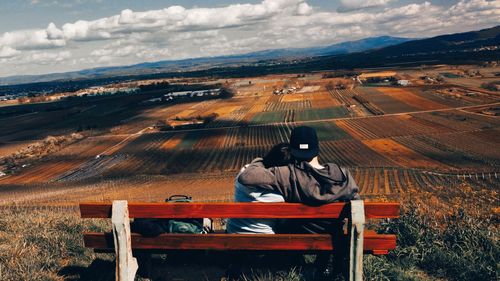 Rear view of man sitting on landscape