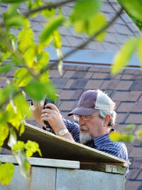 Man drilling wood outdoors