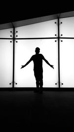 Rear view of silhouette man standing against wall