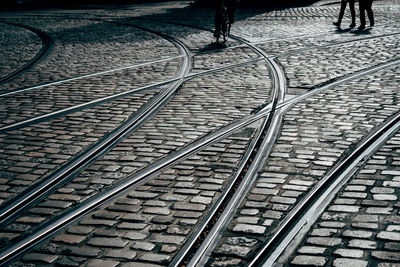 High angle view of railroad tracks on cobbled street in city