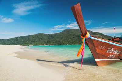 Deck chairs on beach against blue sky