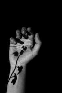 Close-up of human hand against black background