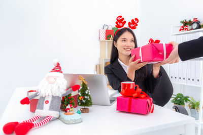 Woman holding red and christmas decorations on table