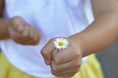 Midsection of girl holding white flower