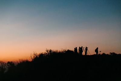 Silhouette people against sky during sunset