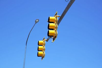 Low angle view of road signal against clear blue sky