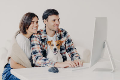 Couple and dog using computer