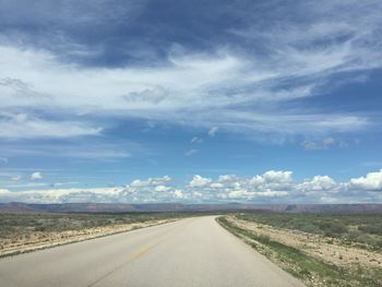 Country road against cloudy sky