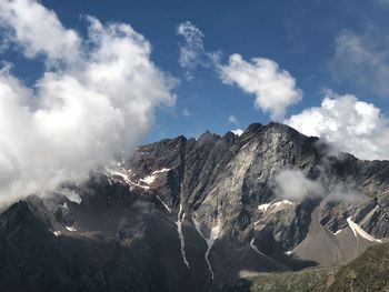 Panoramic view of snowcapped mountains against sky with clouds