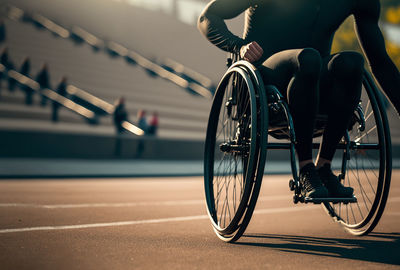 Close up of man in wheelchair sports on an outdoor running track. disabled athlete concept. 