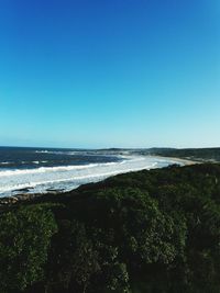 Scenic view of beach against clear blue sky