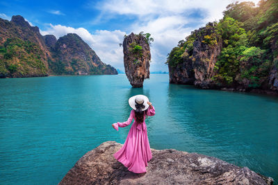 Rear view of woman standing by lake