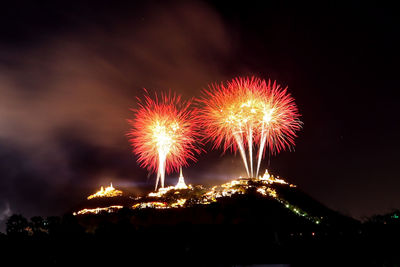 Low angle view of firework display at night