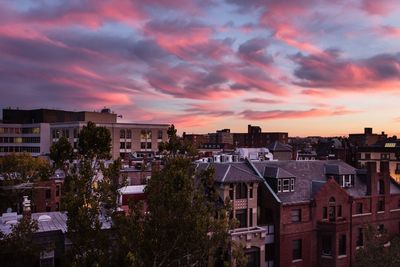 Buildings against cloudy sky at sunset