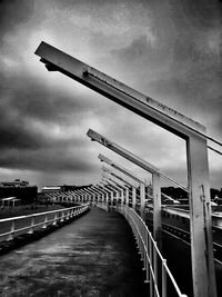 Bridge over river against cloudy sky