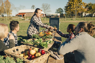 Multi-ethnic male and female farmers selling organic vegetables at market