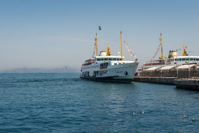 Ship sailing on sea against clear sky