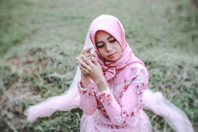 Low section of woman with arms raised on field