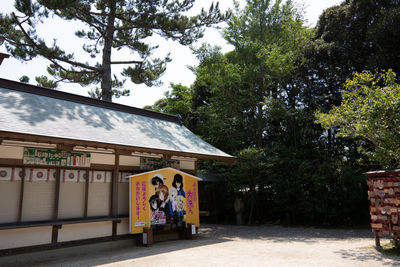 Rear view of people walking by building