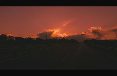 Road against dramatic sky at night