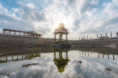 Structure on lake against sky