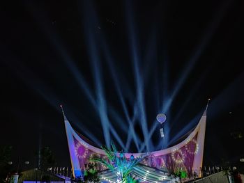 Illuminated lights in city against sky at night