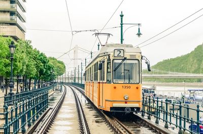 Orange tram along the danube river from erzhebet bridge near belgrade embankment. budapest, hungary