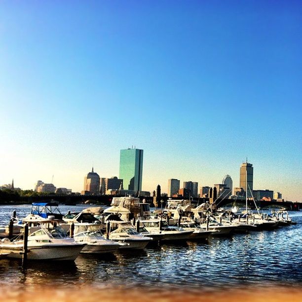 water, clear sky, waterfront, building exterior, architecture, city, sea, nautical vessel, built structure, copy space, blue, boat, skyscraper, urban skyline, cityscape, transportation, office building, mode of transport, skyline, moored