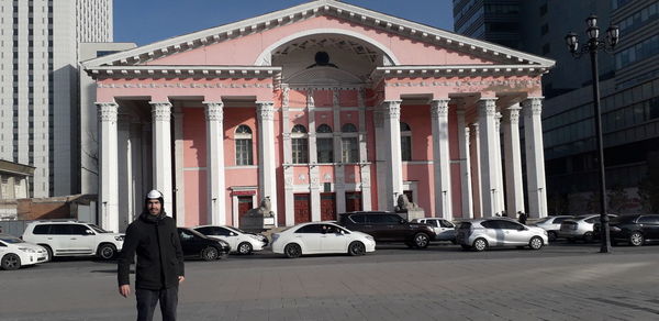 People on street against buildings in city