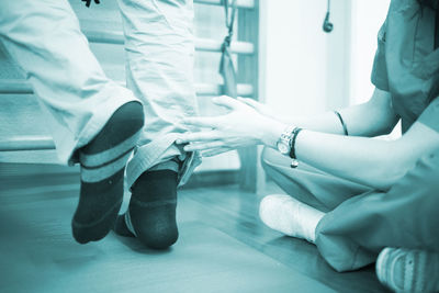 Low section of nurse examining patient at hospital