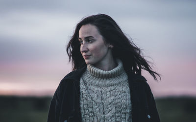 Young woman against sky