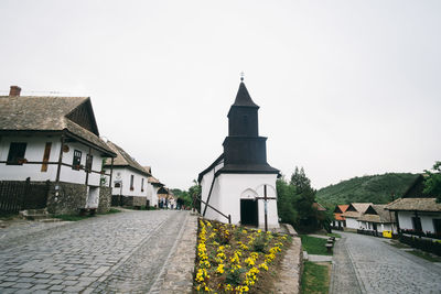 Footpath amidst buildings against sky
