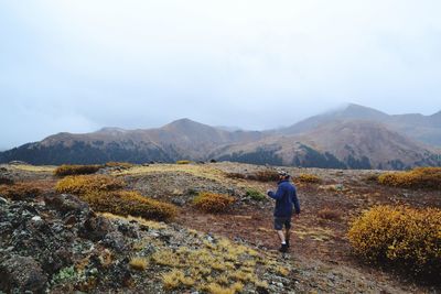 Rear view of man on mountains against sky