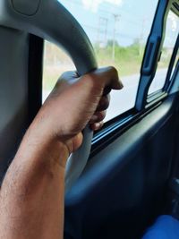 Cropped hand holding handle in train