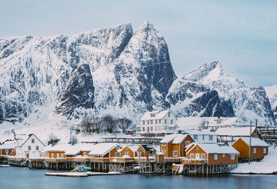 Built structure by sea against sky during winter