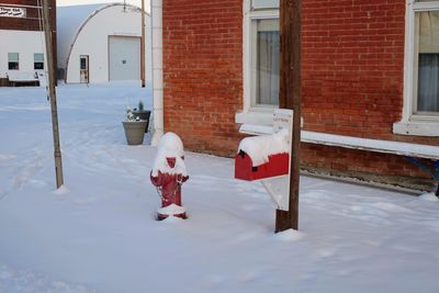 Boy in snow against house