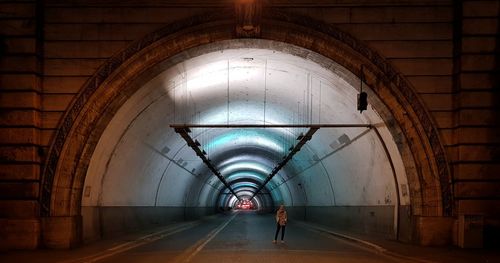 Full length of woman standing in tunnel at night