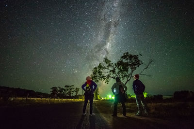 People standing against clear sky at night