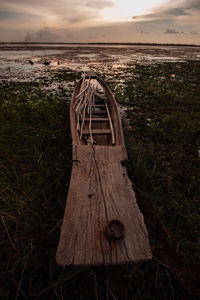 Wooden structure on beach against sky during sunset