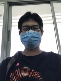 Portrait of young man looking through window