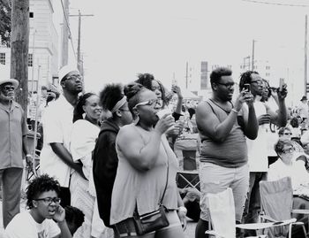 Crowd standing by people in front of building