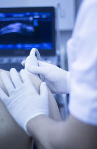 Close-up of doctor examining patient with medical equipment in hospital