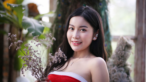 Portrait of smiling young woman with flowers