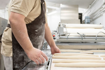 Midsection of chef preparing food in bakery