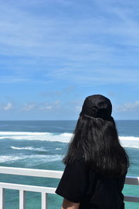 Rear view of woman looking at sea against sky