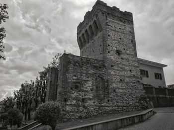 Low angle view of old building against cloudy sky